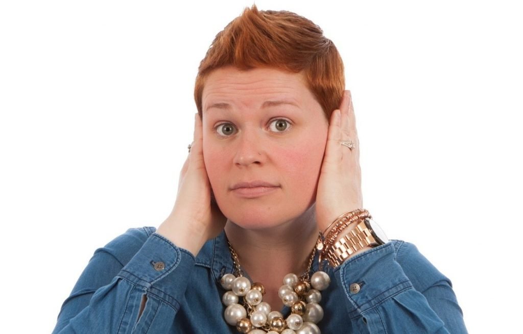 Imagem mostra mulher com mãos nas orelhas - orelha esquerda quente