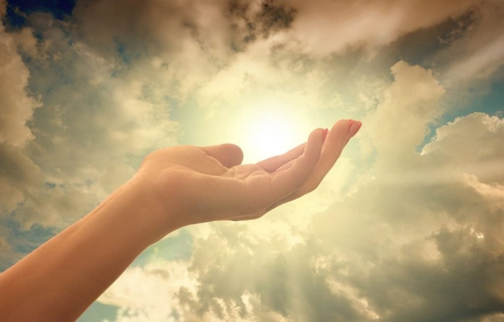 Imagem mostra mão elevada aos céus - frases de espiritualidade