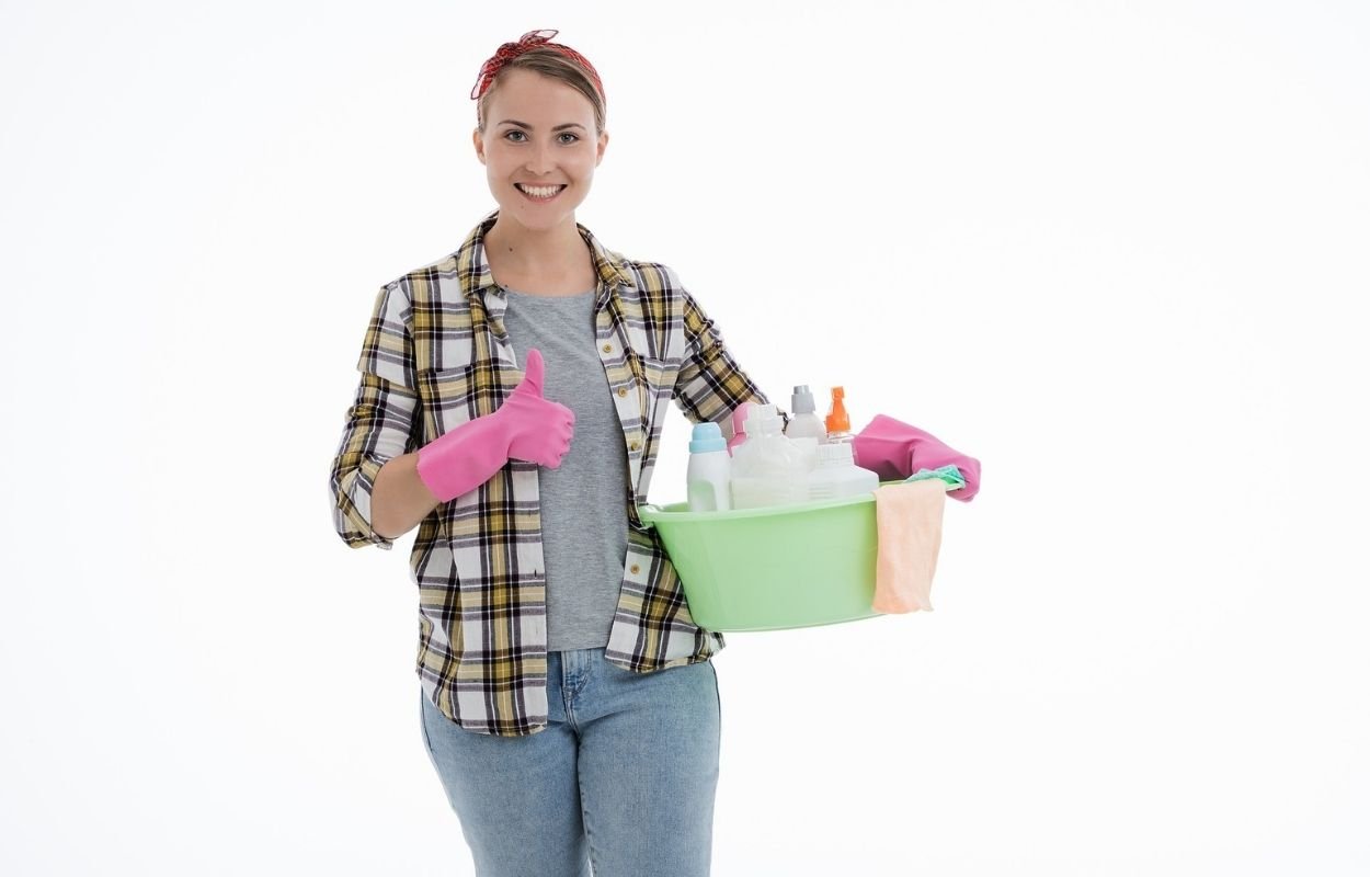 Imagem mostra mulher com itens de limpeza - feng shui no trabalho