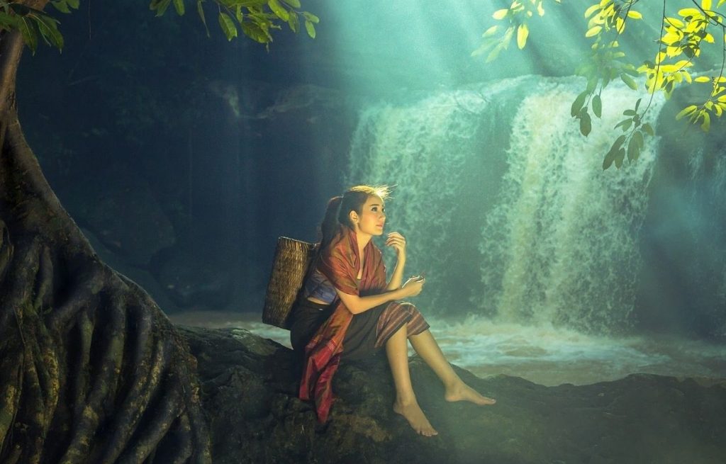 Imagem mostra mulher sentada em meio à natureza - legenda para foto sozinha