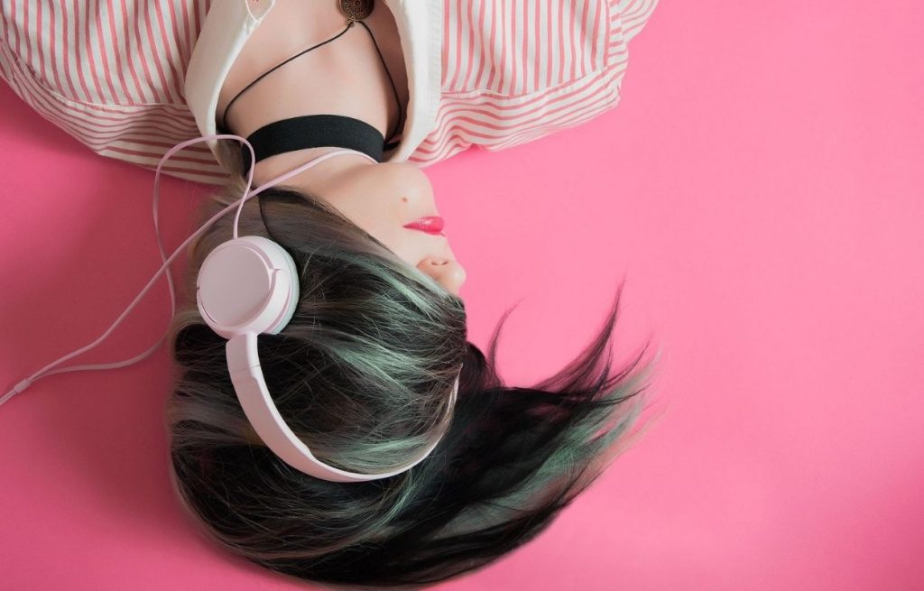 Imagem mostra mulher com fones de ouvido - legendas para fotos com letras de músicas que falam por você