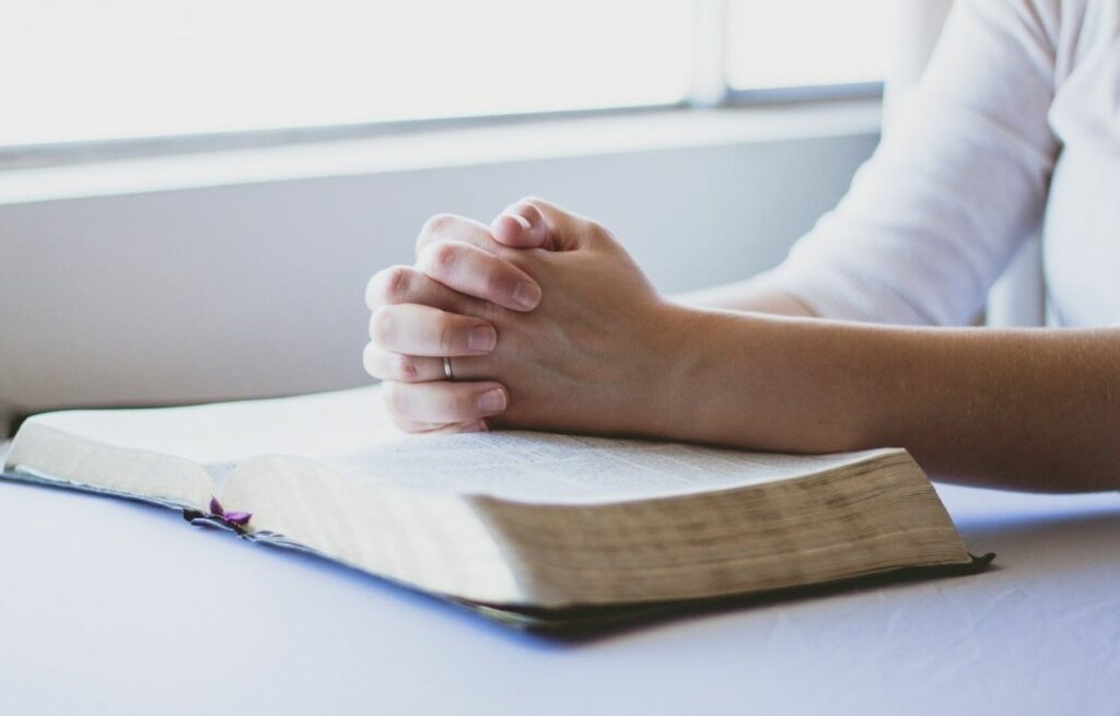 Imagem mostra mãos em prece - oração para mãe