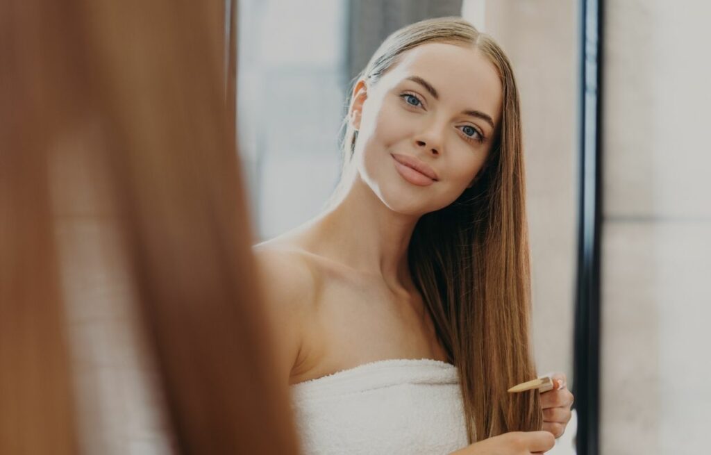 Imagem mostra mulher com cabelos lisos - alisamento caseiro