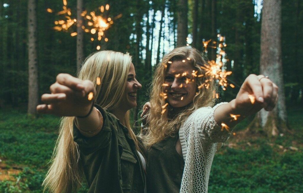 Imagem mostra jovens com velas nas mãos - frases de aniversário para irmã