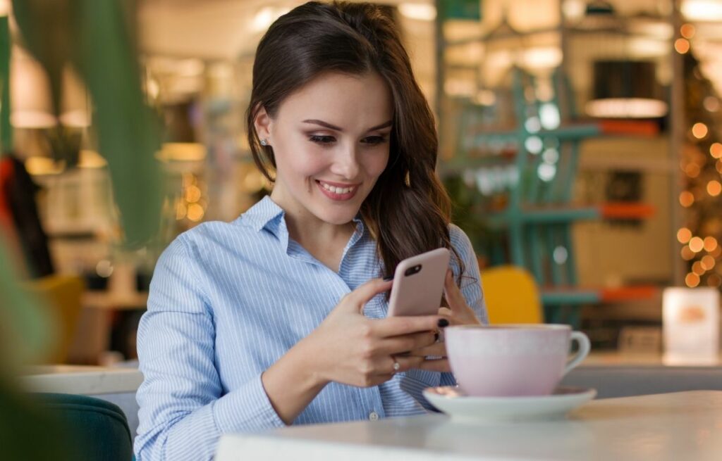 Imagem mostra mulher olhando o celular - frases tumblr 2021