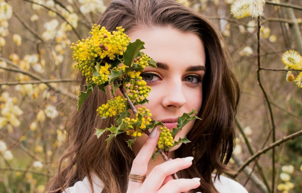 Imagem mostra rosto de mulher junto com flores - mensagem de bom dia